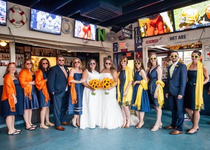 Happy brides at their wedding with their bridal party