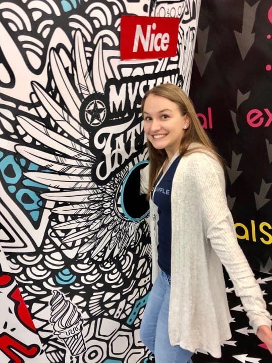 Intern sticking arm into mystery tattoo box at bizbash ny