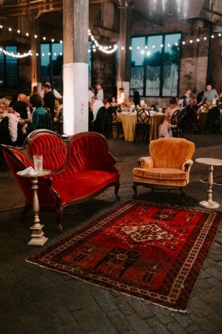 Wedding lounge setup with vintage furniture and carpet with fairy lights