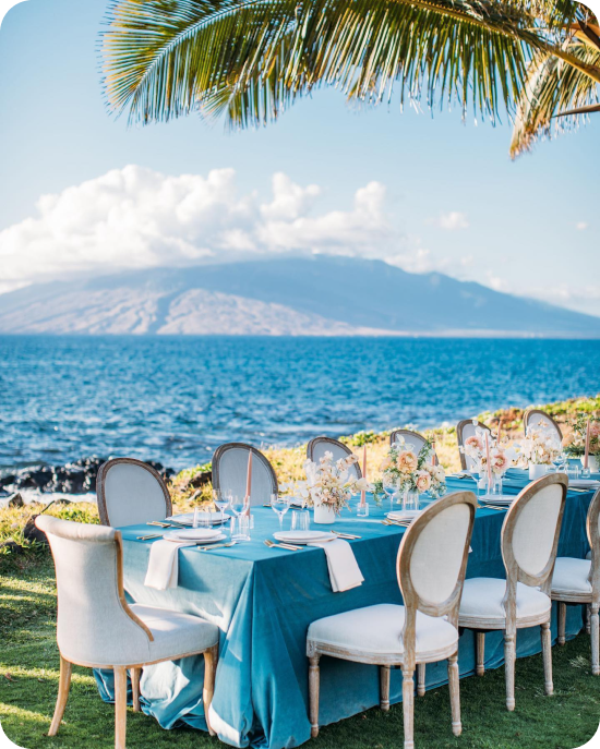 Signature Boutique Event Rentals brings coastal elegance to the cliffside — Louis chairs, teal linen, and a table set so perfectly that the Pacific Ocean had no choice but to show up as the backdrop.