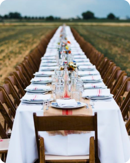 A farm table stretching into the horizon, wooden folding chairs, and white linens that let the landscape do the talking