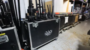 Rows of organized audio, video, and lighting equipment in an event production warehouse