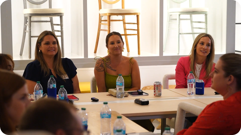 Panelists seated for a roundtable discussion inside an event rental warehouse.