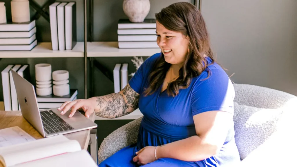 An event designer comparing rental software options on a laptop surrounded by decor and tabletop pieces