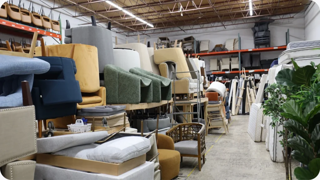 Sofas and lounge chairs grouped by style and shape along a main aisle of the Staging Design DC warehouse, so a missing piece stands out